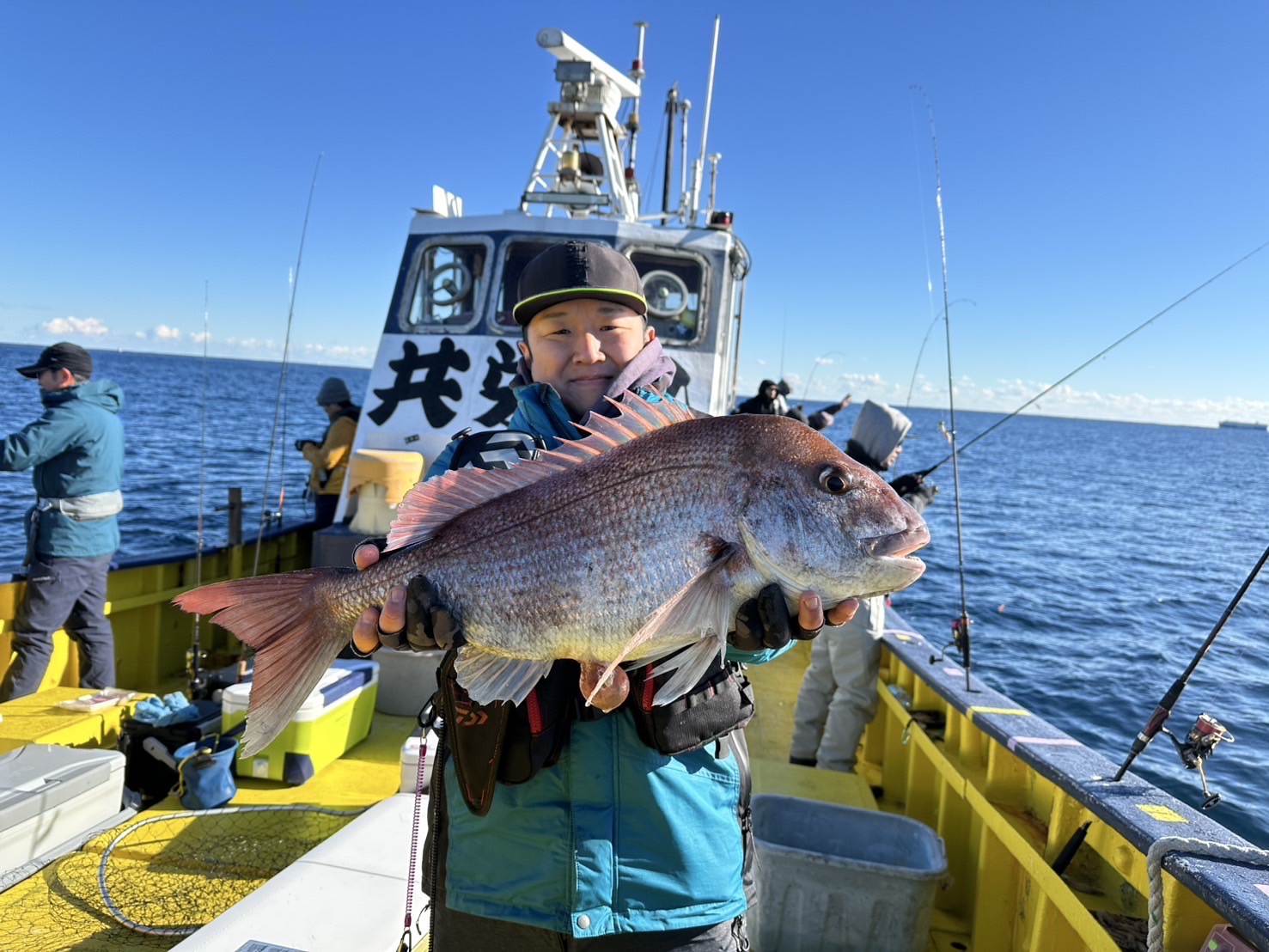共栄丸で釣れたマダイを持つ釣り人